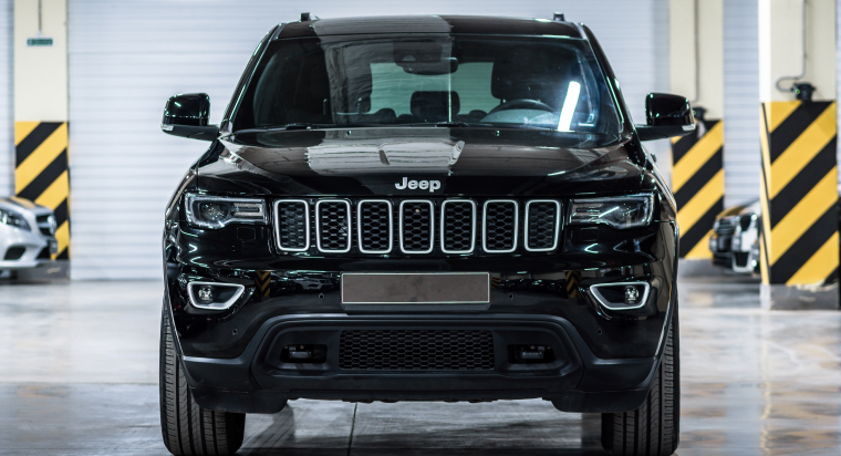 Jeep Cherokee negra en un estacionamiento.