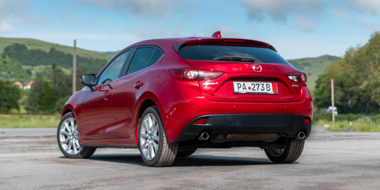 Mazda3 rojo estacionado frente a las montañas