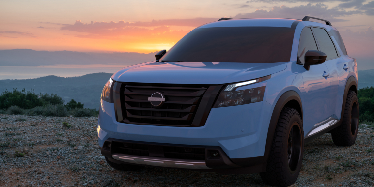 Nissan Pathfinder blanca frente a las montañas en el atardecer