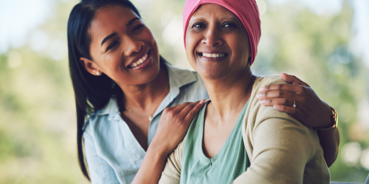 Hija abrazando a su madre enferma de cáncer para darle apoyo y verla sonreír.