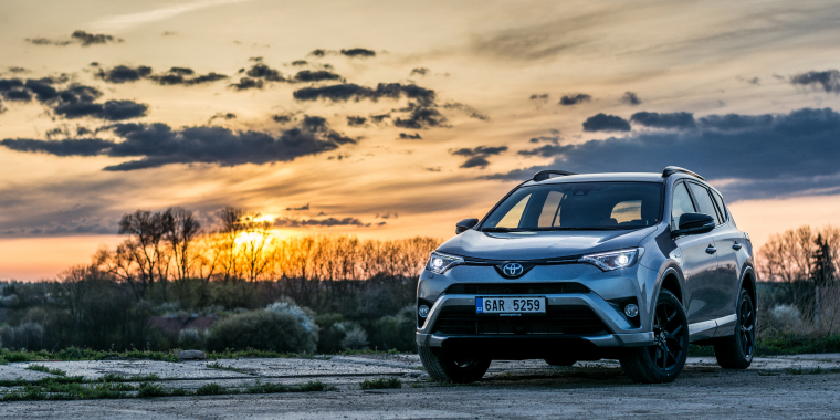 Toyota RAV4 en la carretera bajo el atardecer y el cielo nublado.