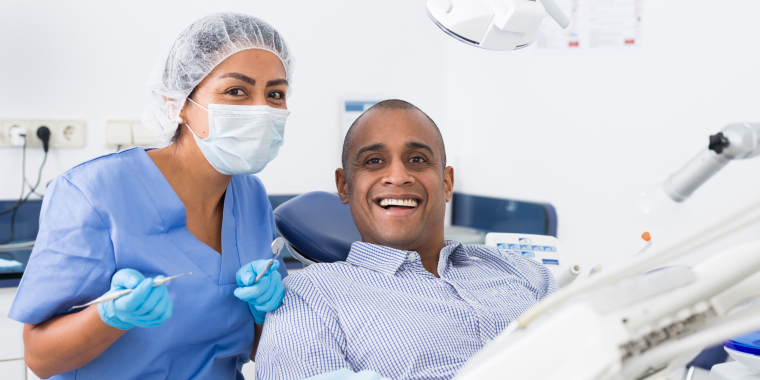Hombre hispano recibiendo sonriendo por recibir atención con su seguro dental.