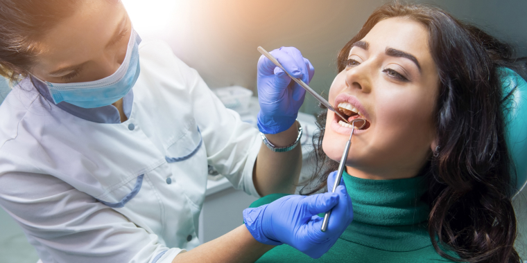Mujer con la boca abierta recibiendo atención médica dental.