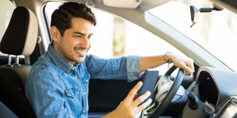 Conductor latino revisando cotizaciones de seguros de automóviles en línea