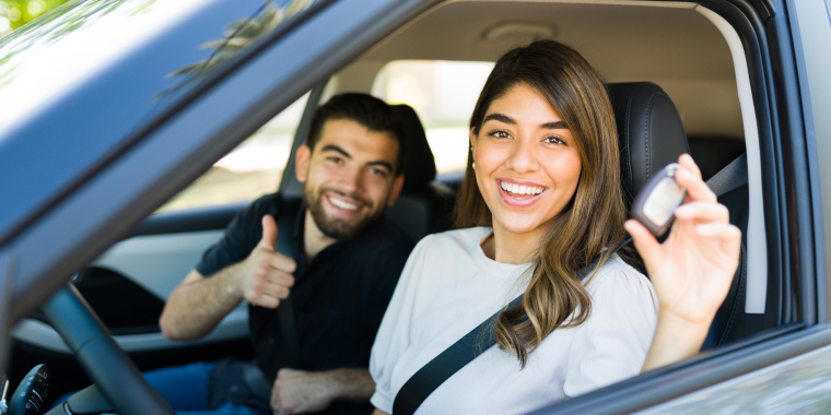 Pareja hispana feliz de tener un seguro de auto para su vehículo