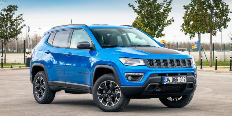 Jeep Compass azul estacionada frente a un parque de juegos