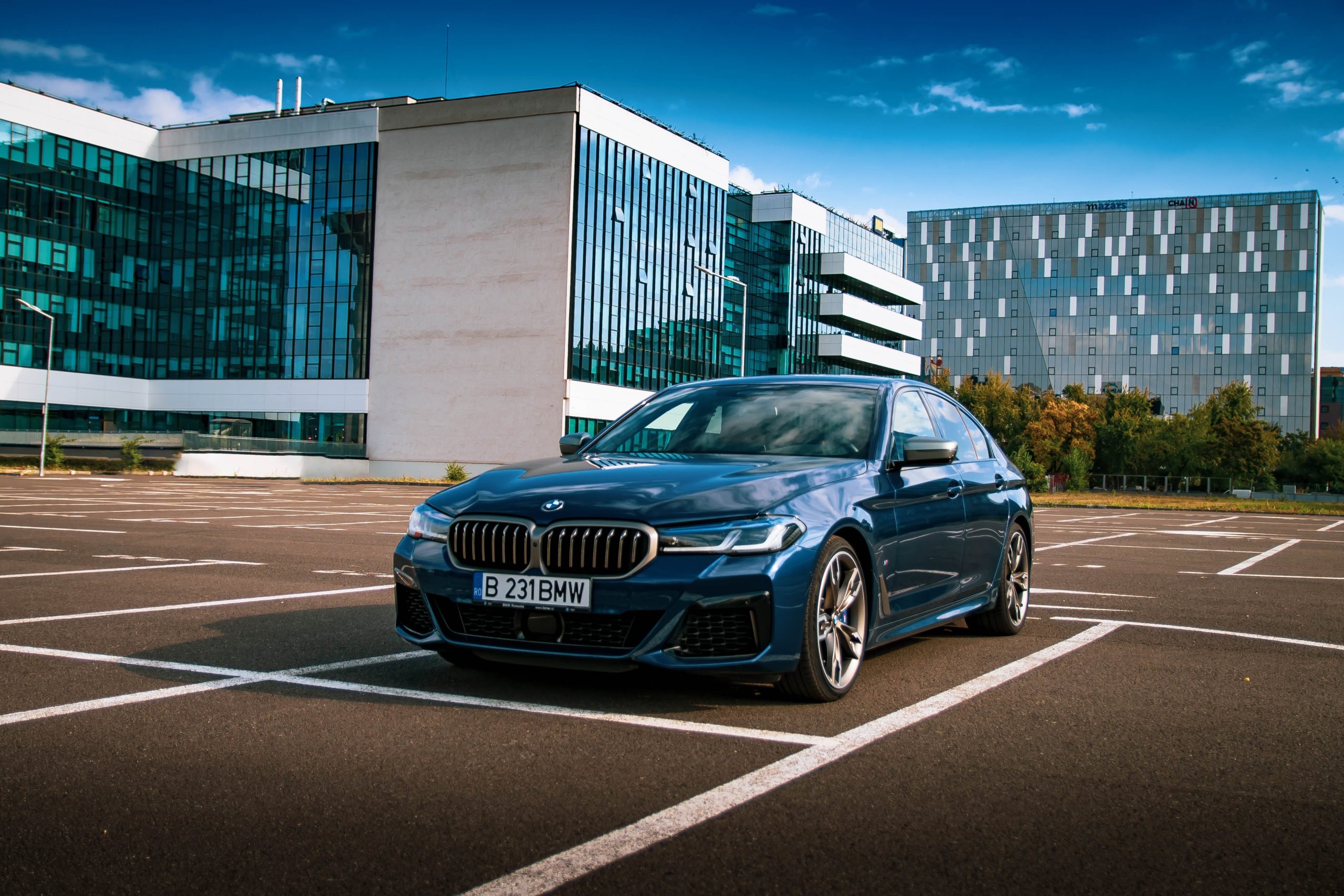 BMW 5 Series parqueado frente a edificios.