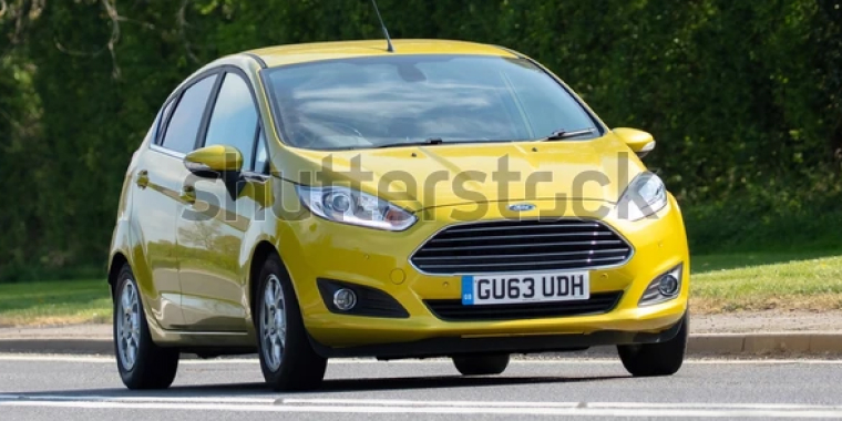 Ford Fiesta amarillo avanzando en la carretera.