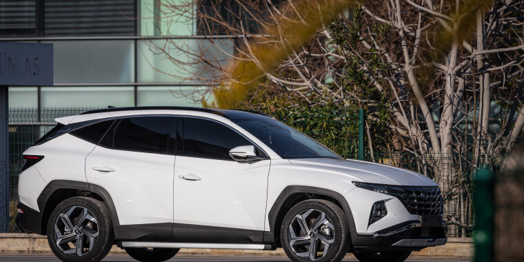 Hyundai Tucson blanca estacionada frente a un edificio bajo el calor del sol