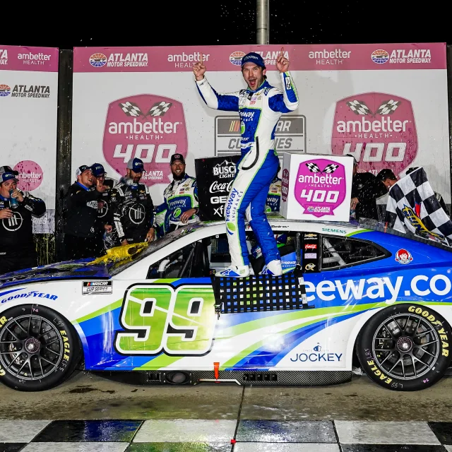 Daniel Suárez parado sobre el Chevrolet Camaro #99 de Freeway Insurance para celebrar su victoria en el Atlanta Motor Speedway.