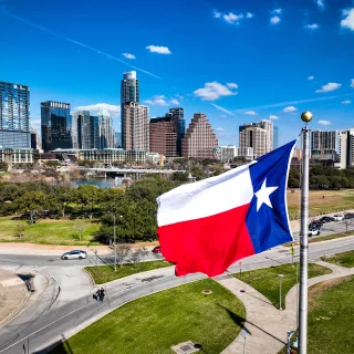 Bandera del estado de Texas ondeando sobre la ciudad de Austin.