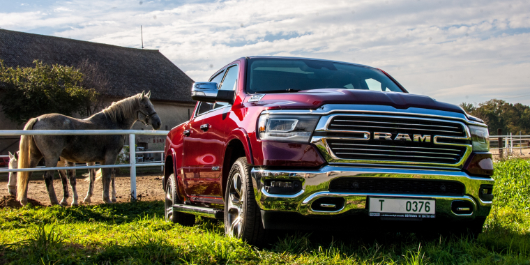 RAM 1500 roja en una granja al lado de un caballo