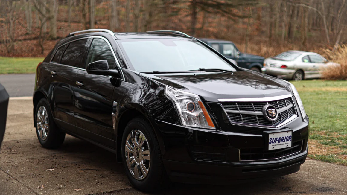 AlCadillac SRX negra estacionada en una tarde de otoño. 