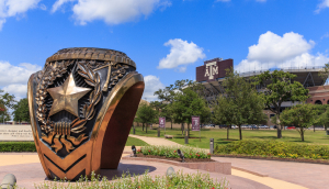 Estatua de anillo en la ciudad de College Station, con estadio de fútbol Kyle Field al fondo. Seguro de auto barato en College Station, Texas.