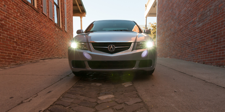 Acura TSX en un callejón con las luces encendidas y frente a la cámara – seguro de auto barato para el Acura TSX.