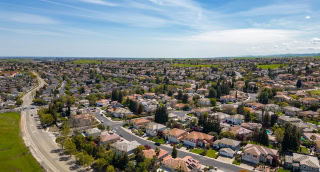 La ciudad de Antioch, California, en un hermoso día soleado con verdes colinas, calles, casas y autos.