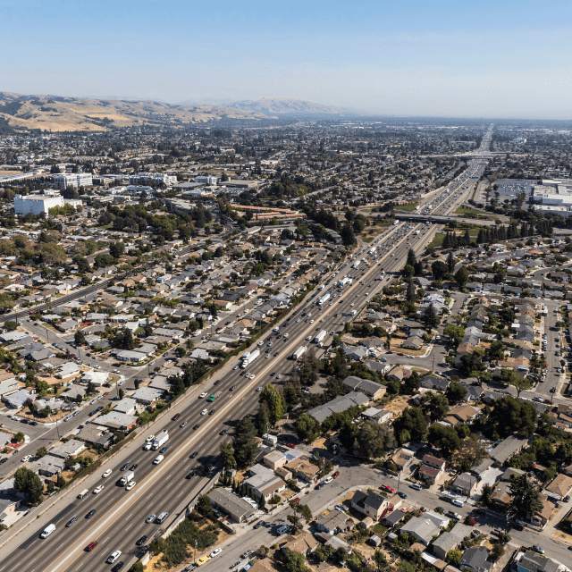 1. Vista aérea de calles, edificios y tráfico a lo largo de la autopista 880 cerca de San Leandro, CA