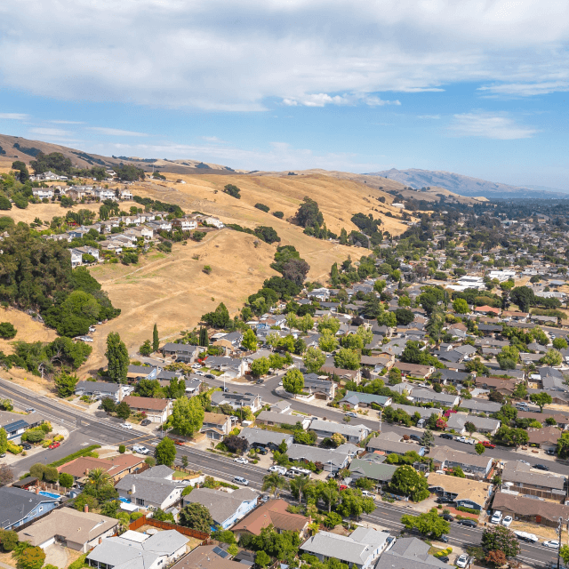 1. Imágenes aéreas sobre un vecindario en Hayward, California, con un cielo azul.