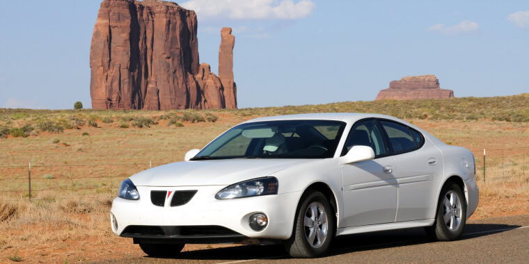 Pontiac Grand Prix color blanco avanzando en el desierto. 