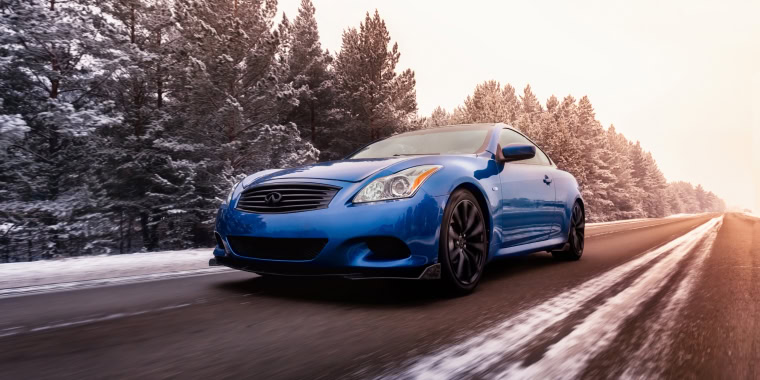 Infiniti G37 avanzando en la carretera bajo el invierno