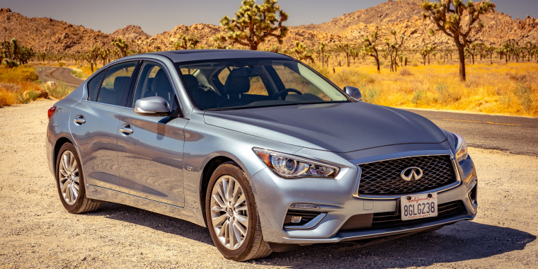 Infiniti Q50 plata estacionado en medio de una carretera vacía durante el día en el Joshua Tree National Park, California.