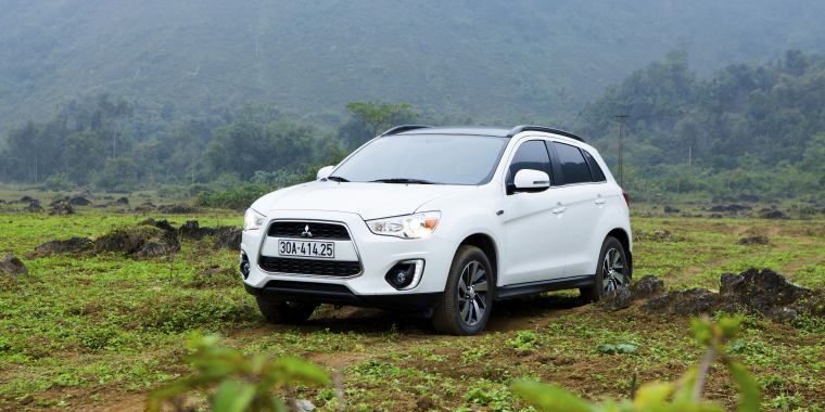 Mitsubishi Outlander Sport estacionada en medio del pasto en un día nublado - Mitsubishi Outlander Sport, seguro de auto barato para Mitsubishi