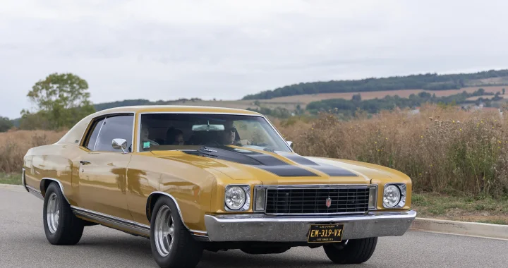 Chevrolet Monte Carlo dorado con líneas negras avanzando en una carretera rural - Seguro de auto barato para el Chevrolet Monte Carlo