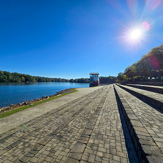 1. Un hermoso paisaje otoñal en el Parque Olímpico Lake Lanier con las aguas ondulantes del lago Lanier, árboles, plantas y hierba verde en Gainesville, Georgia, EE. UU. – Seguro de carro en Georgia