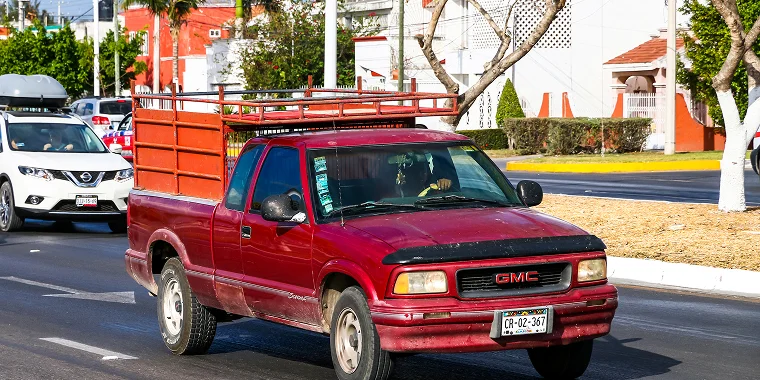 GMC Sonoma roja avanzando en la carretera – GMC Sonoma, seguro de auto barato para GMC