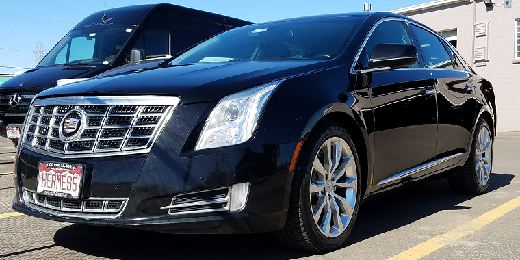 Un Cadillac XTS azul exhibido en una exposición de coches – Cadillac, seguro de carro barato