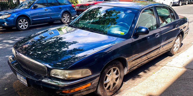 Buick Park Avenue azul avanzando en la carretera - Buick Park Avenue, seguro de auto barato para Buick
