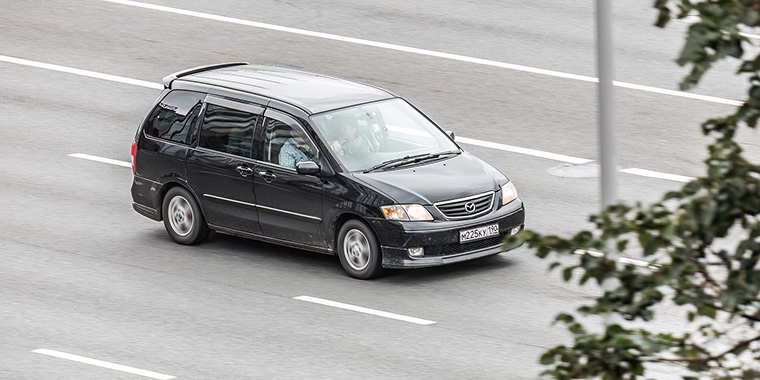Mazda MPV gris oscuro en una autopista – seguro de auto barato para Mazda