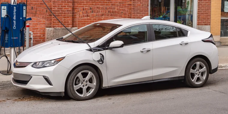 Chevrolet Volt eléctrico conectado a una estación de carga EV en el centro de Montreal. Seguro de auto barato para Chevrolet.