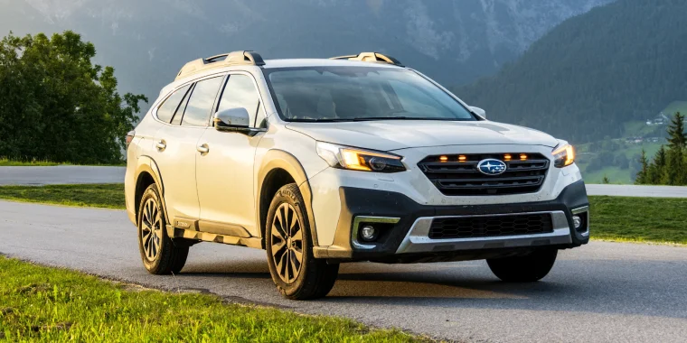 SUV familiar Subaru Outback blanco al atardecer en una carretera de montaña. Seguro de auto barato para Subaru.