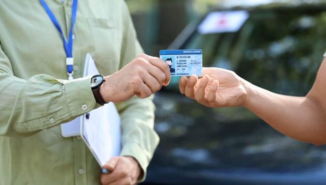 Persona entregando su licencia de conducir durante una cita para obtener o renovar la licencia de conducir.
