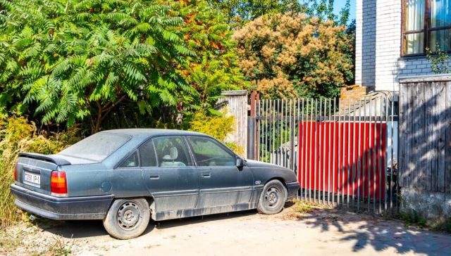 Carro antiguo estacionado frente a una vivienda, ejemplo de un vehículo que podría requerir una cobertura básica al asegurar un carro viejo.