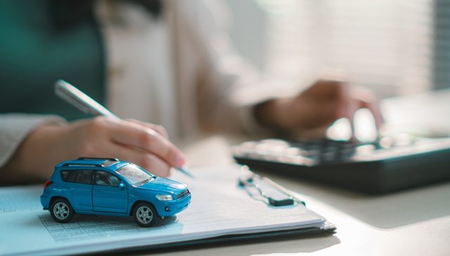 Documentación relacionada con un seguro de auto junto a un vehículo en miniatura, destacando la importancia de completar la solicitud con datos precisos para evitar problemas con la cobertura o el pago de un reclamo.