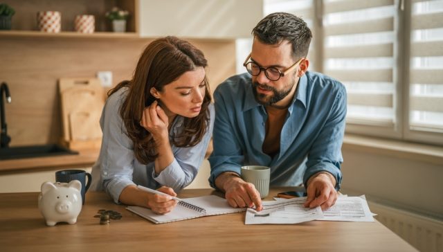 Pareja revisando sus finanzas en casa durante una auditoría financiera personal